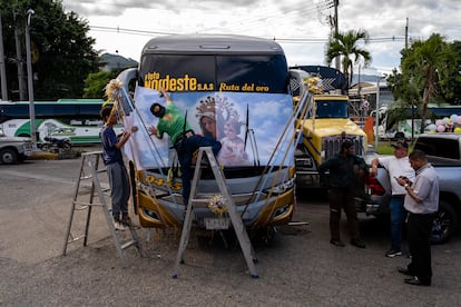 Varias personas decoran un bus en Medellín. La devoción a la Virgen del Carmen en Colombia data de la época colonial, cuando fue adoptada como patrona de los conductores y transportistas para protegerlos en sus recorridos
