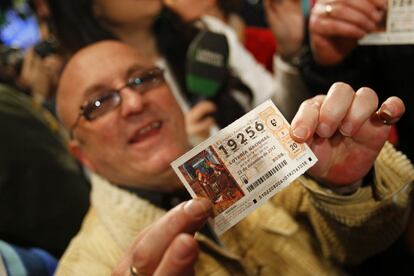 Uno de los asistentes mostrando su d&eacute;cimo de loter&iacute;a.