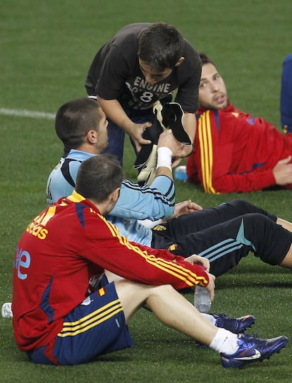 Víctor Valdes le regala los guantes a un aficionado bajo la mirada de Jordi Alba y de Iniesta