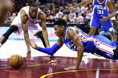 Holmes, de Filadelfia, lucha por el balón con Brown, de Cleveland.