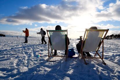 Dos personas toman el sol en Helsinki el pasado 14 de febrero. Finlandia es el país que ocupa el primer puesto en la clasificación del Informe Mundial sobre la Felicidad.