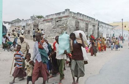 Varios somalíes cargan sus pertenencias desde el sur de Somalia camino de los campos de desplazados en Mogadiscio.