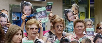 Un grupo de vecinos de C&oacute;rdoba reparte caretas de los ni&ntilde;os desaparecidos en C&oacute;rdoba frente al lugar de trabajo de un familiar de Bret&oacute;n.