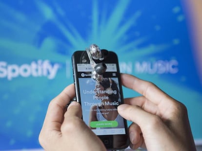 Un usuario con un móvil usa la 'app' de Spotify.