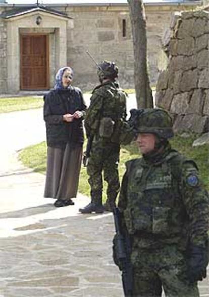 Un soldado de la OTAN habla con una monja ortodoxa ayer cerca de Mitrovica.