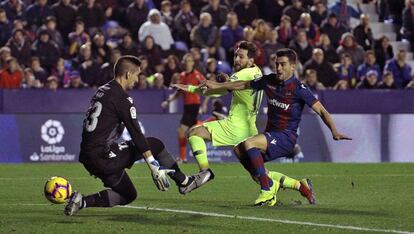 El guardameta del Levante Oier Olazábal y el defensa Sergio Postigo, intentan que Messi no parque gol.