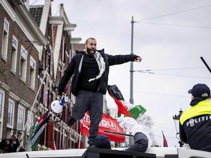 Un manifestante se subía a un vehículo policial durante las protestas en la inauguración del Museo del Holocausto de Ámsterdam este domingo.