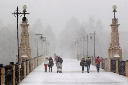 Varias personas entre la nieve en una calle de Teruel. 