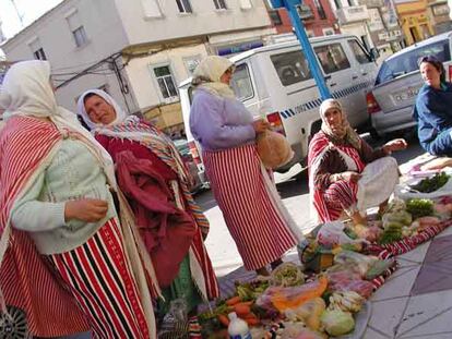 Mujeres musulmanas venden pan y hortalizas en una calle de Ceuta.