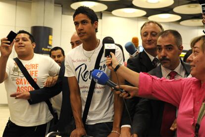 Real Madrid's new signing, Raphaël Varane, surrounded by journalists at Barajas airport