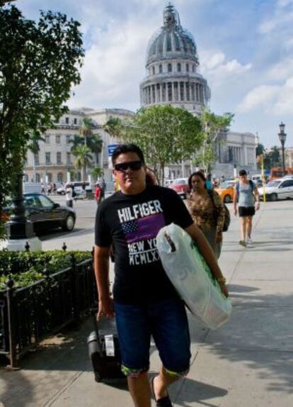 A man wearing an imported US designer t-shirt walks in Havana.