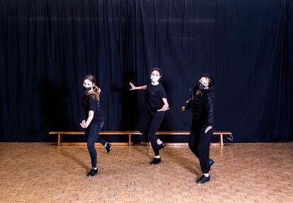 Tres alumnas bailan claqué en una clase.