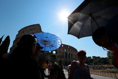 Varios turistas pasean cerca del Coliseo, durante la ola de calor, este lunes 21 de agosto en Roma. 