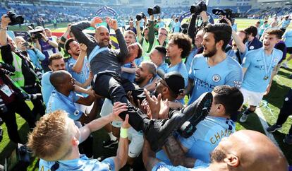 Los jugadores del City mantean a Guardiola durante la celebración del título.