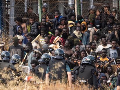Decenas de inmigrantes custodiados por agentes españoles tras cruzar a Melilla desde Marruecos el 24 de junio.