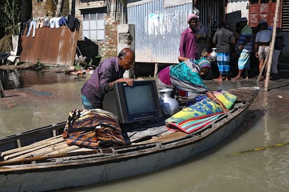 Una familia coloca sus pertenencias en una balsa para mudarse a un lugar a salvo tras perder su casa por las inundaciones en Dacca, Bangladés, en julio de 2020.