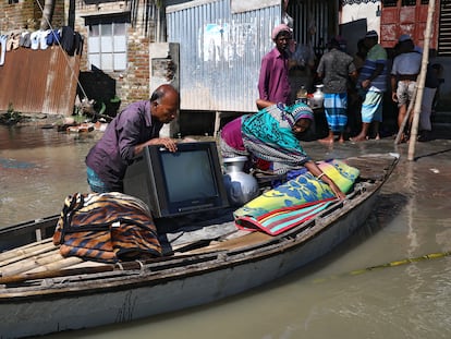 Una familia coloca sus pertenencias en una balsa para mudarse a un lugar a salvo tras perder su casa por las inundaciones en Dacca, Bangladés, en julio de 2020.