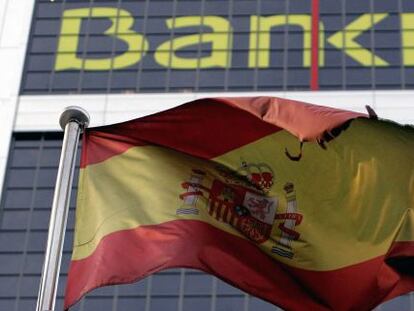 En la imagen, una bandera espa&ntilde;ola que ondea delante de la sede de Bankia en Madrid. EFE/Archivo