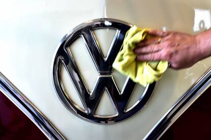 Una persona limpia el símbolo de la marca de coches Volkswagen.