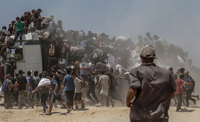 Decenas de gazatíes se agolpan alrededor de un camión con sacos de harina cerca de un punto de distribución de ayuda en el norte de Gaza, este domingo.