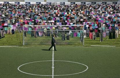 Una artista kosovar desplegó este viernes unos 5.000 vestidos y faldas en el mayor estadio de Kosovo para denunciar las agresiones sexuales contra mujeres que fueron cometidas por tropas militares durante la guerra de Kosovo entre los años 1998 y 1999. Se estima que hubo 20.000 víctimas, según cifras de ONG. En la imagen, un hombre camina ante la exposición reivindicativa, en el estadio de fútbol de Pristina.