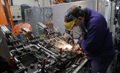 Un operario trabaja sobre la estructura de un asiento de automóvil en la fábrica de Fumiscor en Córdoba.