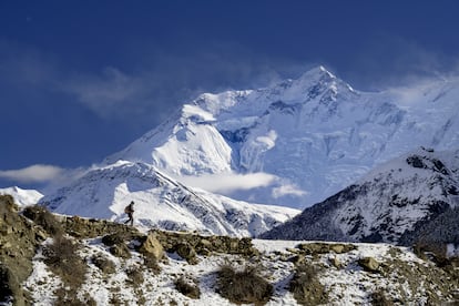 Rinzin Phunjok Lama camina por la región de Humla, con la cumbre de Annapurna de fondo.