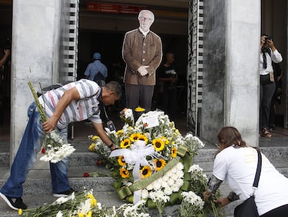 Personas colocan flores frente a la imagen de Botero en un homenaje en el Museo de Antioquia en Medellín (Colombia), este viernes.