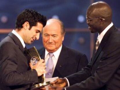 Figo recibe el premio a jugador del año 2001 de las manos de Weah y ante la mirada de Joseph Blatter.