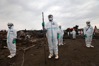 Un grupo de agentes de policía que trabaja en la búsqueda de cadáveres con trajes que les protegen de la radiación en Minamisoma, a 18 km de la central de Fukushima.