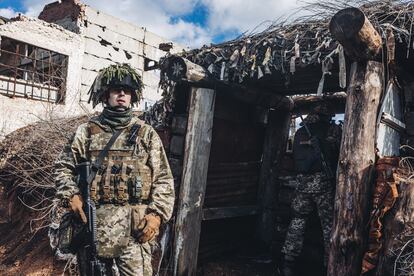 Un soldado ucranio observa mientras otro apunta con su arma desde la trinchera en la línea del frente, el 19 de febrero, en Avdiivka, Oblast de Donetsk (Ucrania).