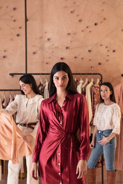 Las diseñadoras de Maksu, Gabrielle Vivanco y Virginia Olaso, posan detrás de la modelo Malena Lite en su tienda, en Madrid.