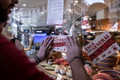 Los huelguistas han colocado pegatinas del paro general en las cristaleras de los comercios por la calle Colón de Valencia.