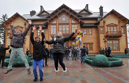 El Parlamento ha decretado este sábado el cese del presidente Viktor Yanukovich y la celebración de elecciones presidenciales "de carácter extraordinario" para el 25 de mayo. En la imagen, uno jóvenes muestra su alegría en el exterior de la casa de Viktor Yanukovych cerca de Kiev.