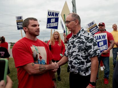Shawn Fain (derecha), presidente del sindicato United Auto Workers, junto a miembros de este en huelga. Trabajan en una planta de GM en Delta Township (Michigan, EE UU).