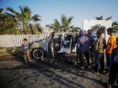 Varias personas observan el estado en el que ha quedado uno de los vehículos de la ONG World Central Kitchen en Gaza.