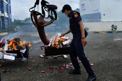 Un funcionario de aduanas quema productos de importación ilegal incautados, en Banda Aceh (Indonesia).