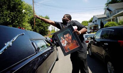 Un hombre lanza una rosa sobre el coche fúnebre que lleva los restos de Muhammad Ali, en Louisville (Estados Unidos).