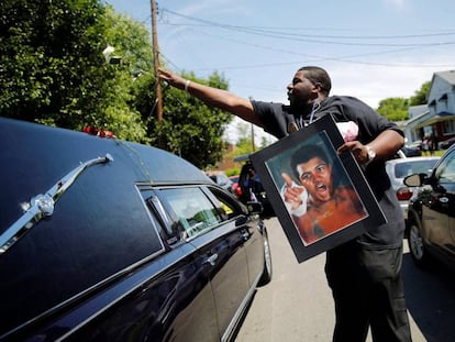 Un hombre lanza una rosa sobre el coche fúnebre que lleva los restos de Muhammad Ali, en Louisville (Estados Unidos).