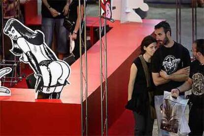 Una pareja pasea junto a uno de los expositores del Salón del Cómic de Barcelona.