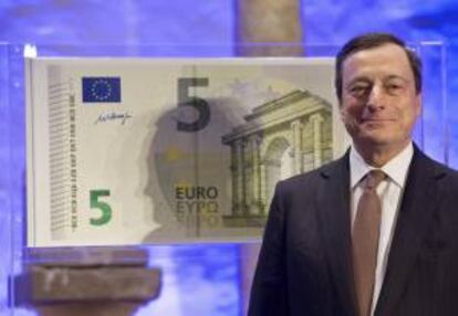 El presidente del Banco Central Europeo (BCE), Mario Draghi, posa al lado de una copia a tamaño gigante del nuevo billete de cinco euros, en Fráncfort, el 10 de enero de 2013. EFE/Archivo