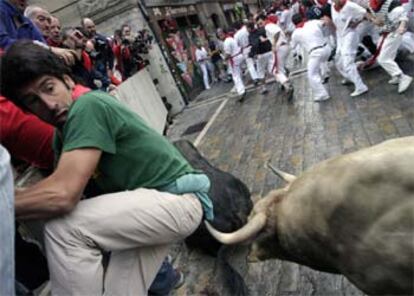 Uno de los astados de Jandilla arremete contra un mozo que participaba en el encierro de San Fermín.