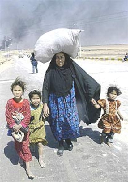 Una mujer iraquí con sus hijos logra escapar de Basora antes de los tiroteos.