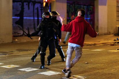 Riot police run at one of the pro-independence protesters.