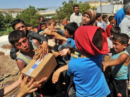 Niños sirios pelean por las cajas de un camión capturado por los rebeldes sirios cerca del puente fronterizo de Bab al-Hawa.