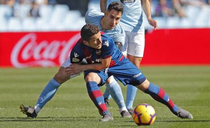 El centrocampista macedonio del Levante, Enis Bardhi, cae ante el defensa del Celta, Hugo Mallo.