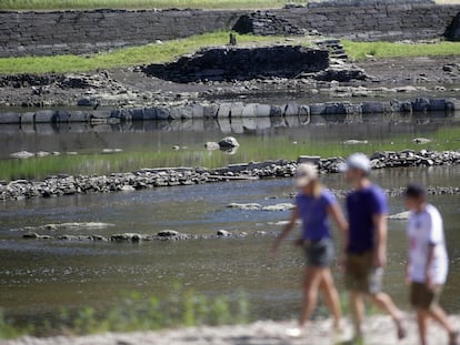 Tres personas observan las ruinas del pueblo viejo de Portomarín (Lugo), el pasado día 27 de julio de 2022, en el pantano de Belesar, que recoge aguas del Miño.