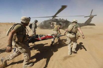 <i>Marines</i> estadounidenses evacuan a un afgano herido durante una operación en Helmand, en octubre pasado.