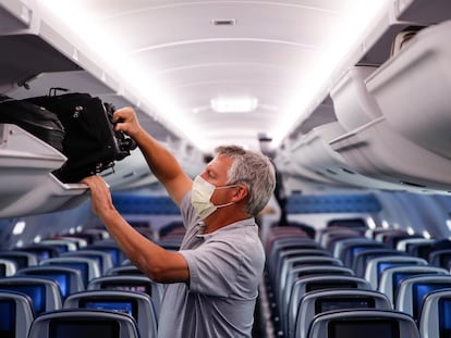Un pasajero de un vuelo protege su rostro con una mascarilla, en una imagen de archivo.