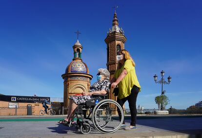 Dos mujeres protegidas con mascarillas junto a la Capillita del Carmen en Sevilla el 2 de mayo